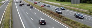 Ansicht von oben auf eine dreispurige Autobahn mit hohem Verkehrsaufkommen.