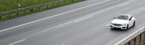 Ein weißer Pkw rast über die Autobahn.