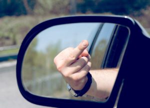 Der ausgestreckte Mittelfinger als Beleidigung im Straßenverkehr.