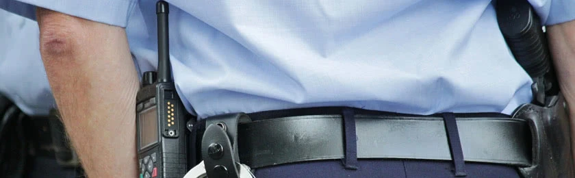 Ein Polizist mit Handschellen am Gürtel.