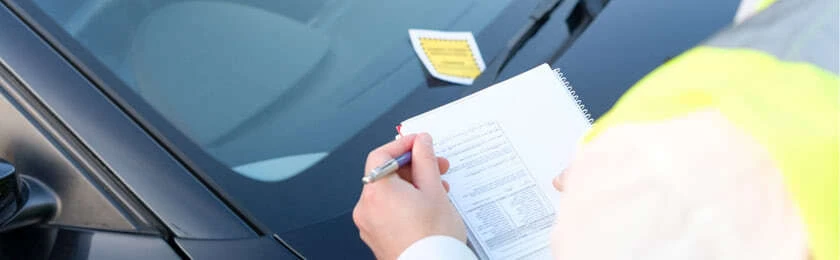 Ein Autofahrer hält Post von der Bußgeldbehörde in der Hand.